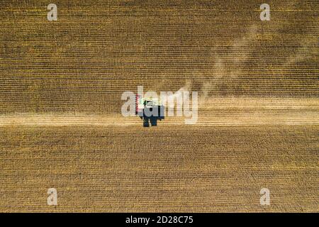 Vista aerea del drone con splendido paesaggio autunnale del trattore in funzione sul campo di raccolta. Concetto di agricoltura. Foto di alta qualità Foto Stock