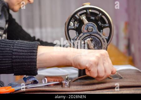 Donna che lavora su una vecchia macchina da cucire. Primo piano delle mani Foto Stock