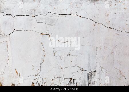 cigolio e scricchiolio parete stucco incrinata con intonaco bianco Foto Stock