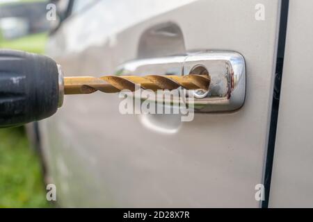 Ladro di auto. Primo piano - con la mano di un uomo che apre l'auto con un cacciavite Foto Stock