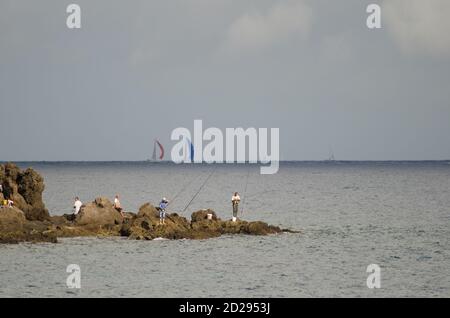 I pescatori e la corsa transatlantica sullo sfondo. Risco Verde. Playa de Arinaga. Aguimes. Gran Canaria. Isole Canarie. Spagna. Foto Stock