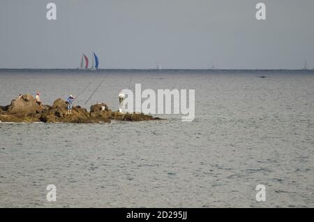 I pescatori e la corsa transatlantica sullo sfondo. Risco Verde. Playa de Arinaga. Aguimes. Gran Canaria. Isole Canarie. Spagna. Foto Stock