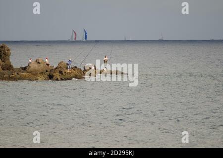 I pescatori e la corsa transatlantica sullo sfondo. Risco Verde. Playa de Arinaga. Aguimes. Gran Canaria. Isole Canarie. Spagna. Foto Stock