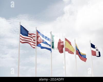 molte bandiere nazionali colorate di diversi paesi su alberi all'aperto su sfondo blu cielo nuvoloso, simboli di usa cuba irlanda spagna venezuela e repubblica dominicana Foto Stock