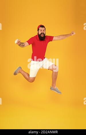 Verso il divertimento. Uno stile di vita attivo. Felice ragazzo che salta. Uomo con bearded attivo in movimento sfondo giallo. Hippster attivo ed energetico. Carica di energia. Sano ragazzo sentirsi bene. Concetto ispirato. Foto Stock