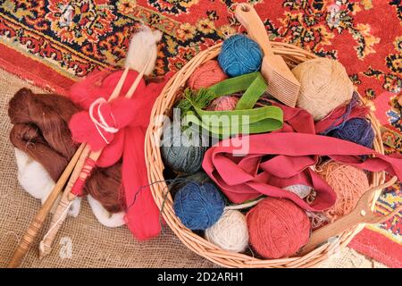 Matasse di filo con pettini in un cestello, primo piano. Utensili da cucire, bastoni di legno per maglieria. Foto Stock