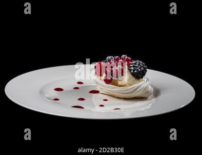 Deliziosa torta con frutti di bosco: Ribes rosso, mirtilli, more. Crema e bella forma. Dessert nel ristorante. Cibo. Isolato su nero ba Foto Stock