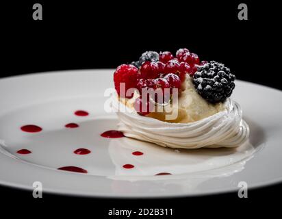 Deliziosa torta con frutti di bosco: Ribes rosso, mirtilli, more. Crema e bella forma. Dessert nel ristorante. Cibo. Isolato su nero ba Foto Stock