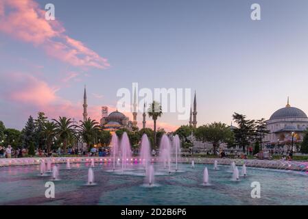 Moschea Blu a Istanbul all'alba con fontana in primo piano e nuvole rosa Foto Stock