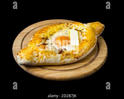 Khachapuri adjariano con uova e formaggio. Cucina georgiana. Isolato su sfondo nero. Foto Stock