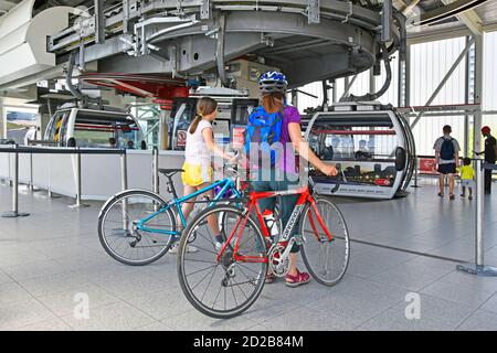 I ciclista e la loro bicicletta aspettano di salire a bordo del trasporto per Londra Emirates Air Line cable car coppia ciclisti e viaggi in bicicletta Alta sul Tamigi Inghilterra Foto Stock