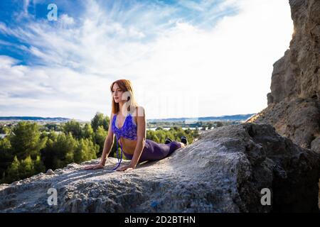 Donna caucasica che pratica yoga in montagna Foto Stock