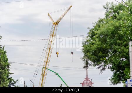 Un gancio di gru su uno sfondo di cielo e alberi. Il concetto della costruzione Foto Stock