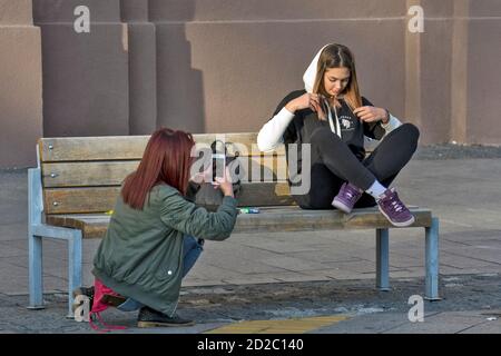 Zrenjanin, Serbia, 05 ottobre 2019. Due ragazze, studenti, stanno riposando su una panchina nel centro della città. Godono di una bella giornata piacevole e di aria fresca. Foto Stock