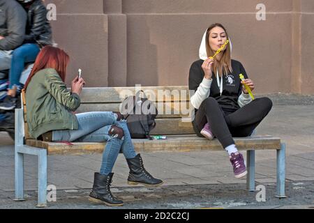 Zrenjanin, Serbia, 05 ottobre 2019. Due ragazze, studenti, stanno riposando su una panchina nel centro della città. Godono di una bella giornata piacevole e di aria fresca. Foto Stock