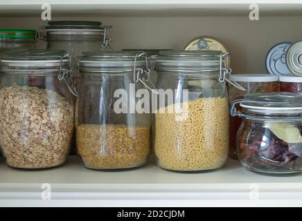 Separazione in un armadio da cucina o dispensa con cereali e. prodotti in scatola Foto Stock