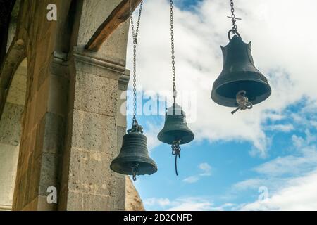 tre campane nella chiesa per le lingue catturati le corde delle campane, sullo sfondo del cielo nuvoloso Foto Stock