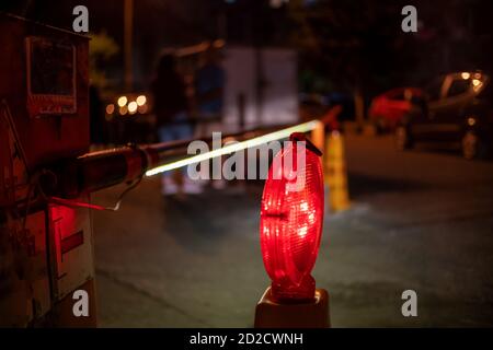 la barriera automatica rossa e bianca si illumina in prossimità del cortile di notte Foto Stock