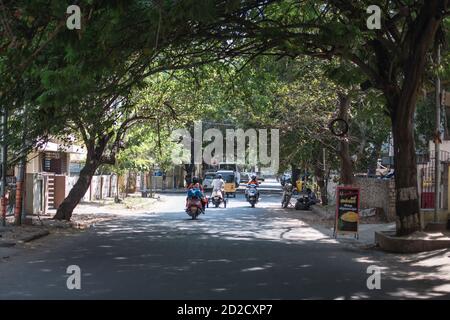 Chennai, India - 8 febbraio 2020: Traffico quotidiano su una strada asfaltata sotto alberi sovrastanti l'8 febbraio 2020 a Chennai, India Foto Stock