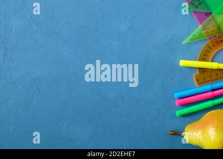 Qualche cancelleria per la scuola sulla superficie blu Foto Stock