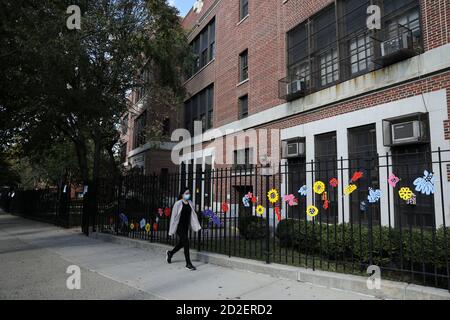 New York, Stati Uniti. 6 Ott 2020. Una passeggiata pedonale passa accanto a una scuola pubblica in Kew Gardens, una delle aree COVID-19 hotspot a New York City, Stati Uniti, 6 ottobre 2020. Le scuole pubbliche e non pubbliche in nove codici di avviamento postale di New York City (NYC) sono state chiuse martedì mattina per un'abbondante cautela contro la pandemia COVID-19, ha detto Bill de Blasio sindaco di NYC alla sua conferenza stampa. I nove codici di avviamento postale hanno visto circa il 3% di positività dei test del coronavirus per sette giorni consecutivi, ha detto de Blasio. Credit: Wang Ying/Xinhua/Alamy Live News Foto Stock