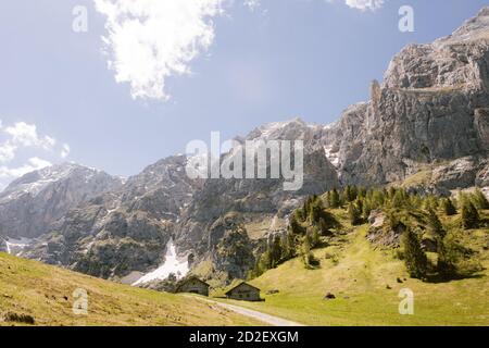 Strada per un rifugio isolato rifugio rifugio rifugio Rifugio Scarpa sulle Alpi italiane. Paesaggio delle Dolomiti, un prato verde e cielo nuvoloso sulla cima della montagna Foto Stock