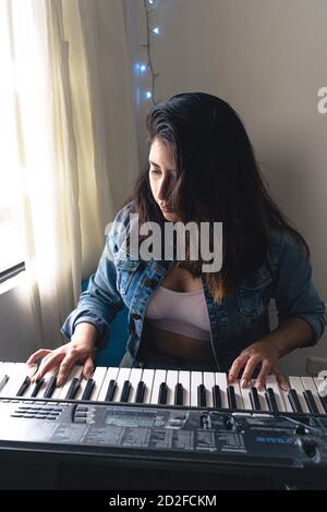 Ragazza che suona piano durante il blocco Foto Stock