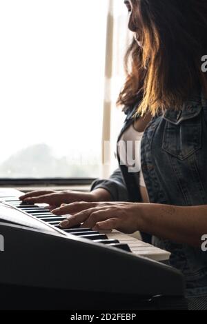 Ragazza che suona piano durante il blocco Foto Stock