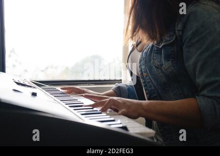 Ragazza che suona piano durante il blocco Foto Stock