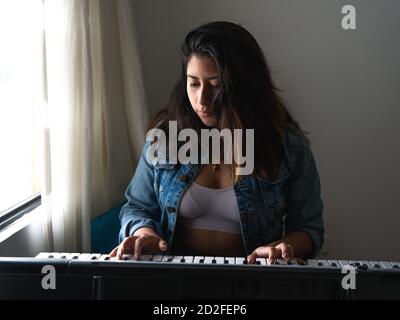 Ragazza che suona piano durante il blocco Foto Stock