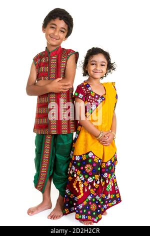 Fratelli e sorelle visualizzati costumi indiani tradizionali indossati durante il Festival indù di Navriri nello stato del Gujarat, India , isolato, bianco Foto Stock