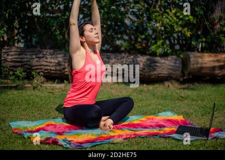 Donna che pratica pilates lezione online Foto Stock