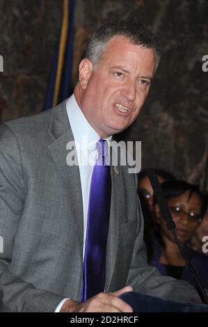 NEW YORK, NY - OTTOBRE 15: Il sindaco di New York Bill de Blasio (R) parla come moglie, First Lady of the City of New York Chirlane McCray (L) guarda durante una cerimonia per illuminare l'Empire state Building in onore del mese nazionale di sensibilizzazione alla violenza domestica presso l'Empire state Building il 15 ottobre 2014 a New York City. Persone: Sindaco Bill de Blasio credito: Hoo-me / MediaPunch Foto Stock