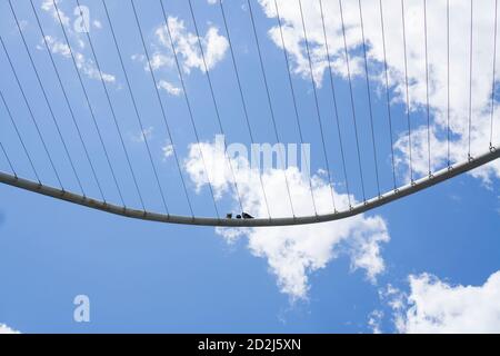 Tre piccioni seduti su una costruzione metallica ad arco con sfondo del cielo Foto Stock