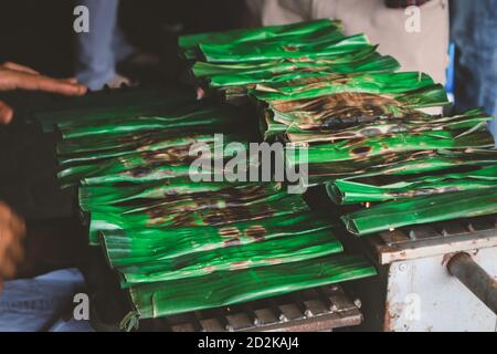 Cucina o grigliatura di cibo locale tradizionale otak otak in Indonesia. Realizzato con torte di pesce alla griglia di Betawi, Jakarta. Foto Stock