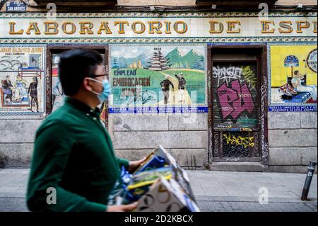 Madrid, Spagna. 06 ottobre 2020. Un uomo che indossa una maschera facciale cammina di fronte al bar chiuso sulla strada del quartiere di Malasaña. La Comunità di Madrid richiede al governo spagnolo di sospendere il confinamento nell'area metropolitana di Madrid per salvare l'economia, Tuttavia oggi la Spagna ha registrato quasi 12 mila infezioni di Covid 19 e più di 250 morti, quasi la metà di esso proviene dalla comunità di Madrid. Credit: SOPA Images Limited/Alamy Live News Foto Stock