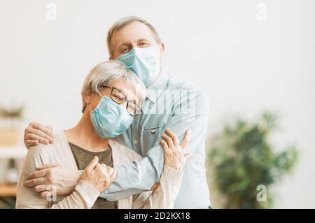 Coppia senior che indossa maschere durante il coronavirus e l'epidemia di influenza. Protezione contro virus e malattie, quarantena domestica. COVID-2019. Assunzione o presa di Foto Stock