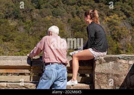 Great Falls, VA, USA 10/03/2020: Un uomo anziano e sua figlia adolescente guardano le grandi cascate, da un punto panoramico. La ragazza indossa pantaloncini Foto Stock