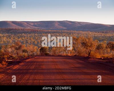 Unsealed Weano Road al tramonto, Parco Nazionale Karijini, Australia Occidentale, Australia Foto Stock