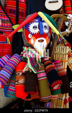 Una maschera colorata e tessuto in vendita in un negozio al mercato delle streghe a la Paz, Bolivia. Il mercato è gestito da medici streghe locali noti come yatiri. Foto Stock