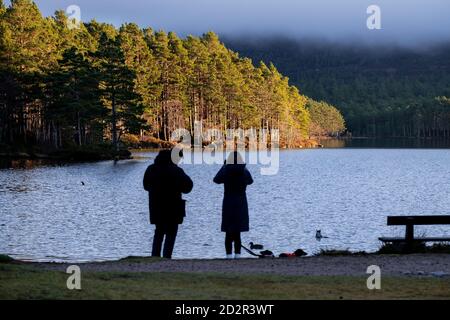 pareja caminando en la senda, bosque de Rothiemurchus, Loch an Eilein, Parque Nacional de Cairngorms, Highlands, Escocia, Reino Unido Foto Stock