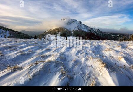 Campo di montagna con picco in inverno, neve paesaggio Foto Stock