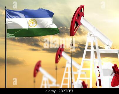 Le piattaforme petrolifere si fanno sullo sfondo del cielo colorato e di un flagpole con la bandiera del Bashkortostan. Il concetto di produzione di petrolio, minerali, sviluppo Foto Stock