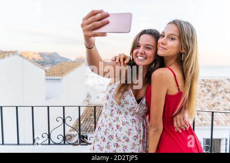 Amici che prendono selfie sulla terrazza Foto Stock