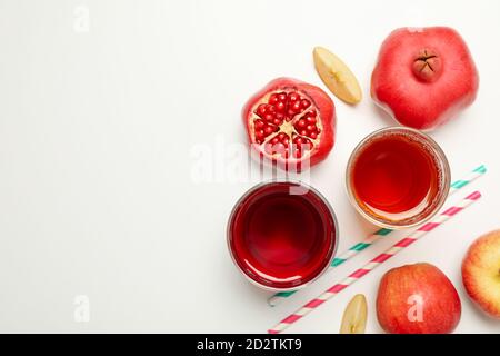 Bicchieri con succhi di mela e melograno su fondo bianco Foto Stock