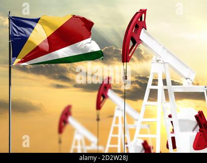 Le piattaforme petrolifere sullo sfondo del cielo colorato e un flagpole con la bandiera delle Seychelles. Il concetto di produzione di petrolio, minerali, sviluppo di Foto Stock
