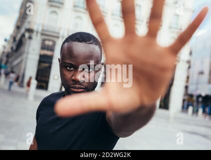 uomo che protesta ad un raduno per l'uguaglianza razziale che alza le braccia mostrando mano alla macchina fotografica. Le vite nere contano. Foto Stock