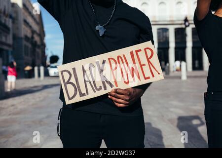 L'uomo anonimo protestando ad un rally per l'uguaglianza razziale che tiene un manifesto del 'potere nero'. Le vite nere contano. Foto Stock