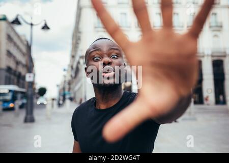 uomo che protesta ad un raduno per l'uguaglianza razziale che alza le braccia mostrando mano alla macchina fotografica. Le vite nere contano. Foto Stock