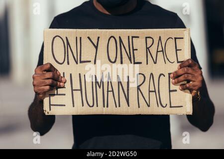 uomo anonimo che protestava per un raduno per l'uguaglianza razziale contro il razzismo. Le vite nere contano. Foto Stock